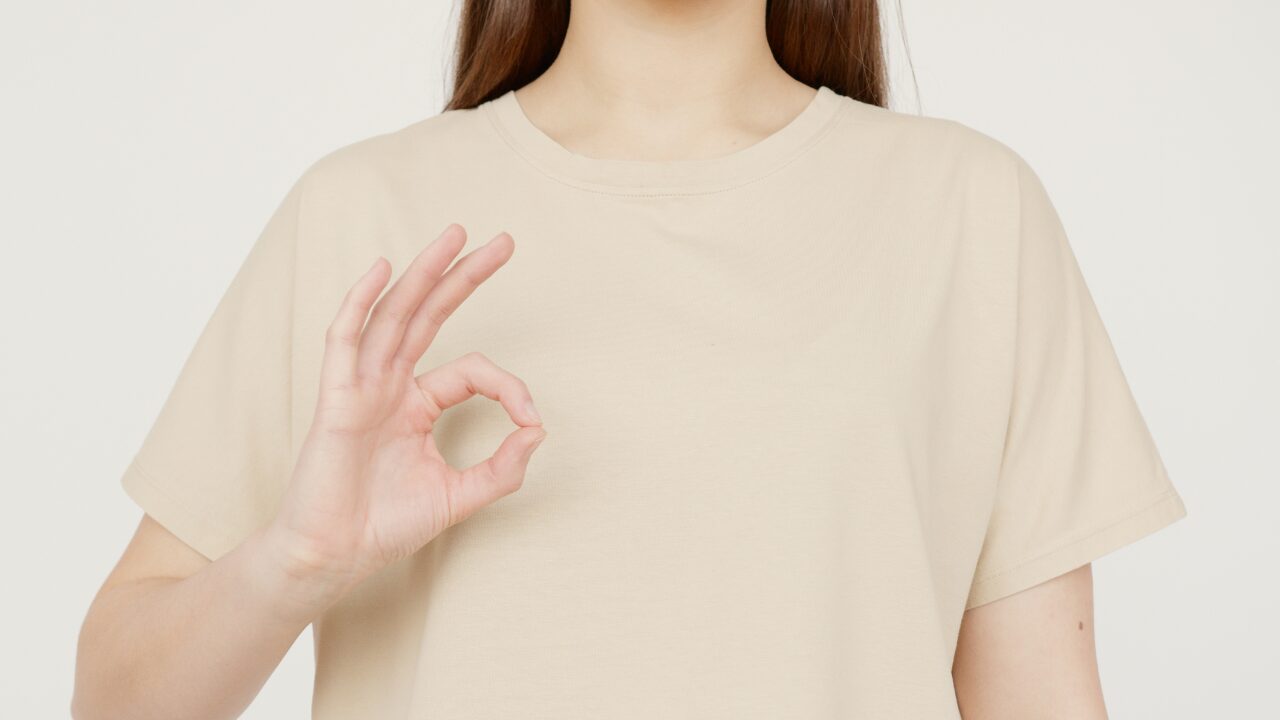 手でOKサインを出す人
